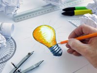 Designer drawing a light bulb, concept for brainstorming and ins